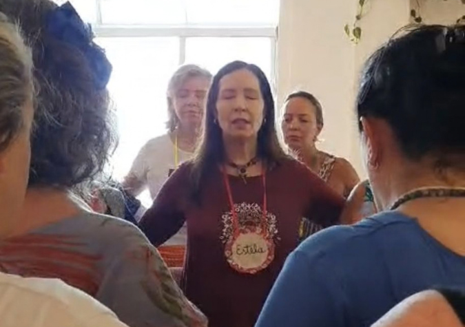 Pessoas de mãos dadas em roda, dando os primeiros passos na dança circular