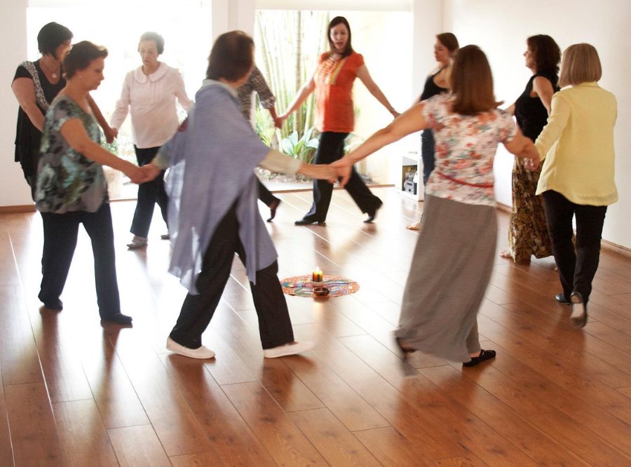 Mulheres de mãos dadas dançando em roda
